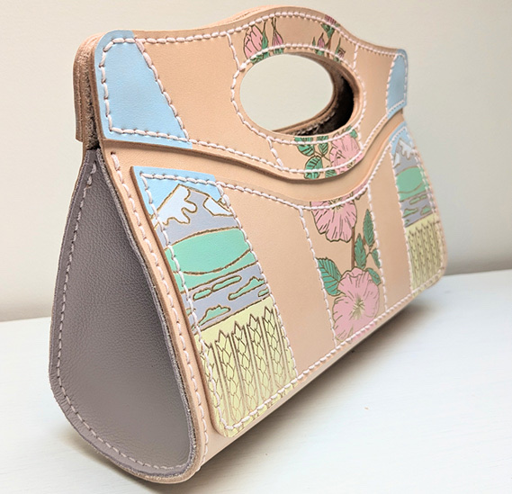 “Alberta Clutch Purse”, 2025 — structured clutch with prairie-sky panels, pink roses and cut-out handle