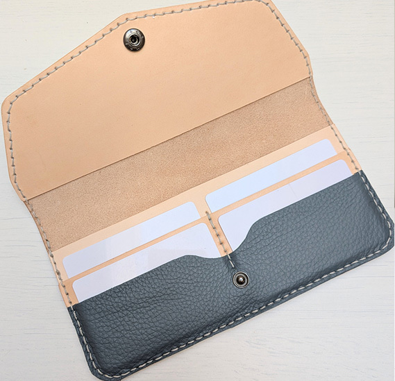 Interior of the “Calla Lily Moth Wallet”, 2025 — natural tan leather with slate-grey card panel and saddle stitching