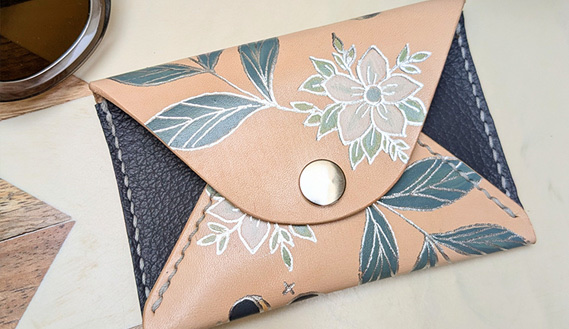 Moon-phase envelope wallet in tan and navy leather with foiled blossom and leaf detail